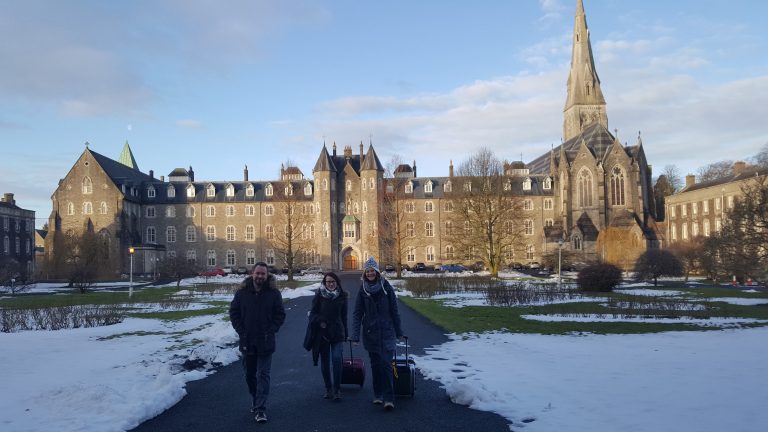 3 Personen im Hintergrund ein herrschaftliches Gebäude