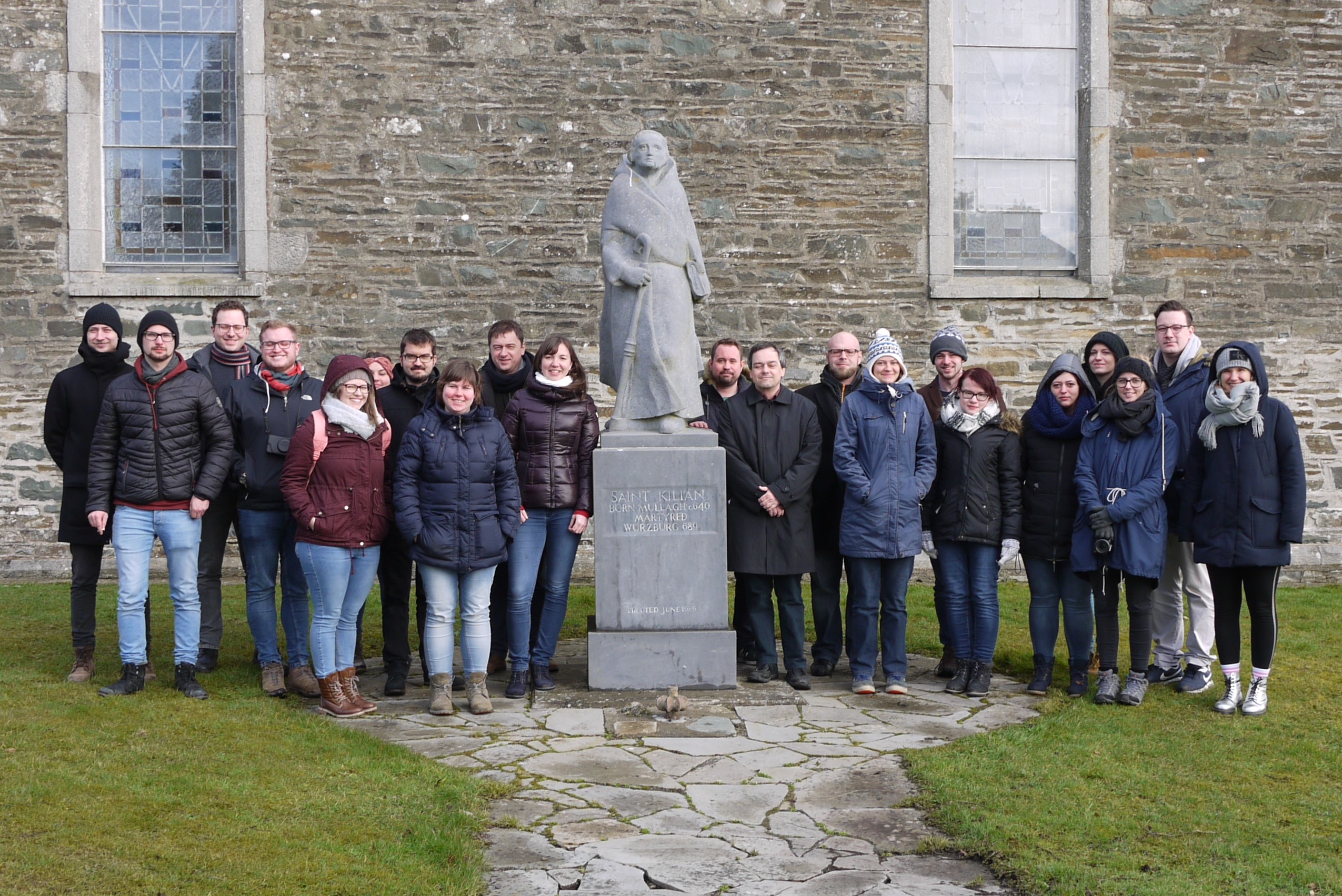 Foto mit mehreren Personen in der Mitte eine statue des Heiligen Kilian