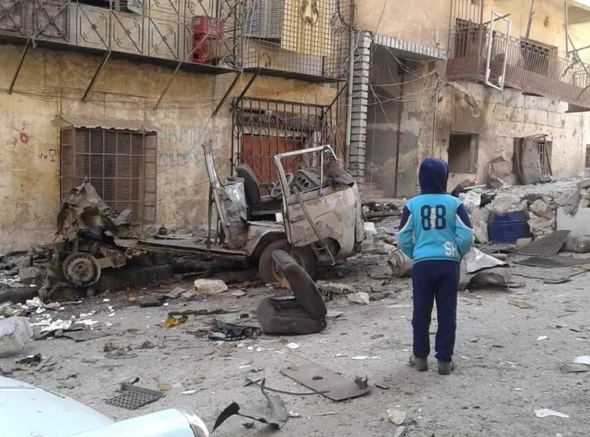 Foto von Kriegszerstörung in Aleppo, im Vordergrund ein Kind von hinten zu sehen