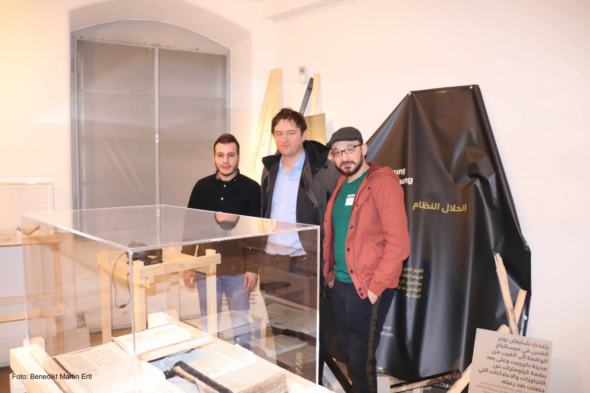 3 Personen vor einer Ausstellungsvitrine