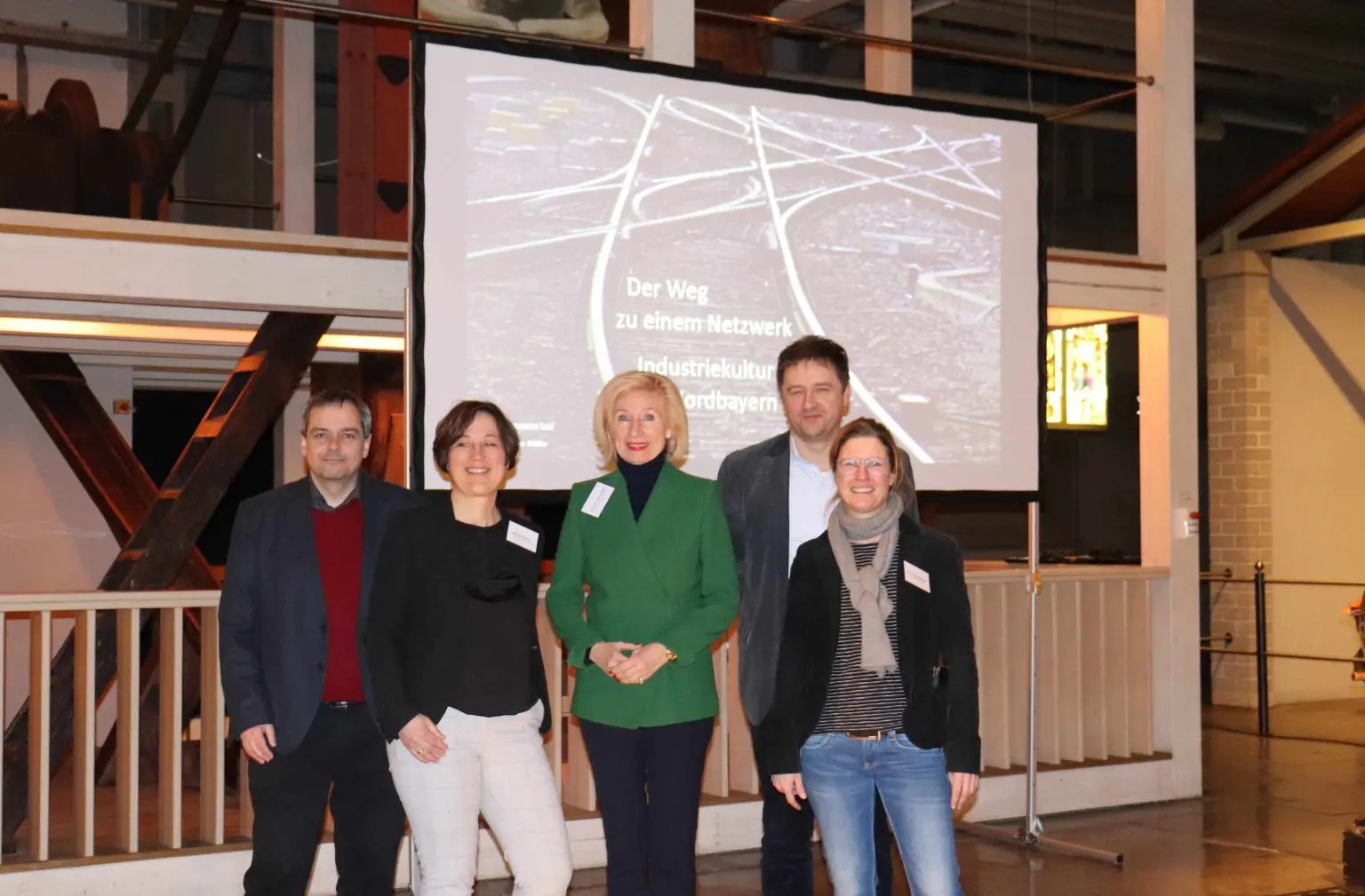 Foto von fünf Personen vor einem Bildschirm