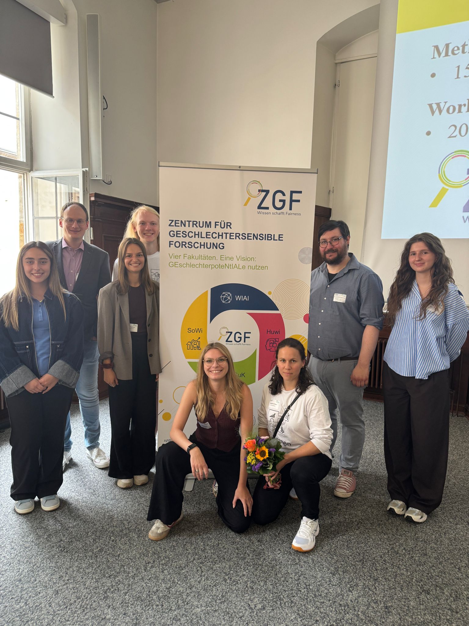 Mehrere Personen vor einem Roll-Up des Zentrum für Geschlechternsensible Forschung